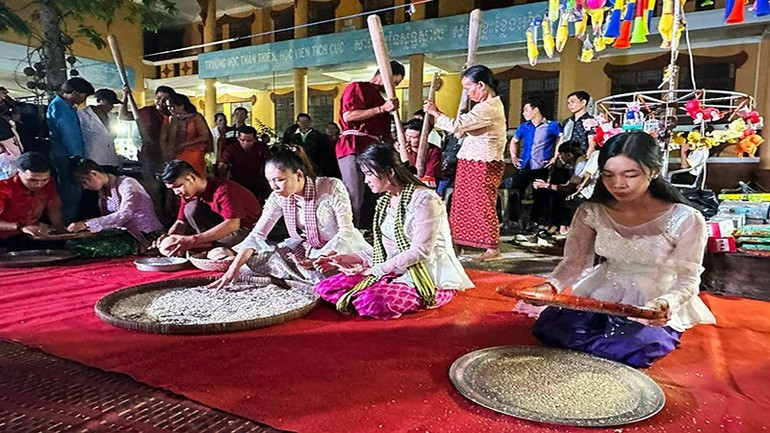 Recreating the process of making com dep (flattened green rice flakes). (Photo: nhandan.vn) le-hoi-oc-om-boc-12825-5.jpg