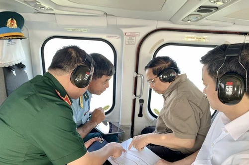 Prime Minister Pham Minh Chinh (second from right) conducts an aerial inspection of the Ca Mau–Dat Mui expressway, the road leading to Hon Khoai, and the dual-use Hon Khoai port from a helicopter. (Photo: VNA) 