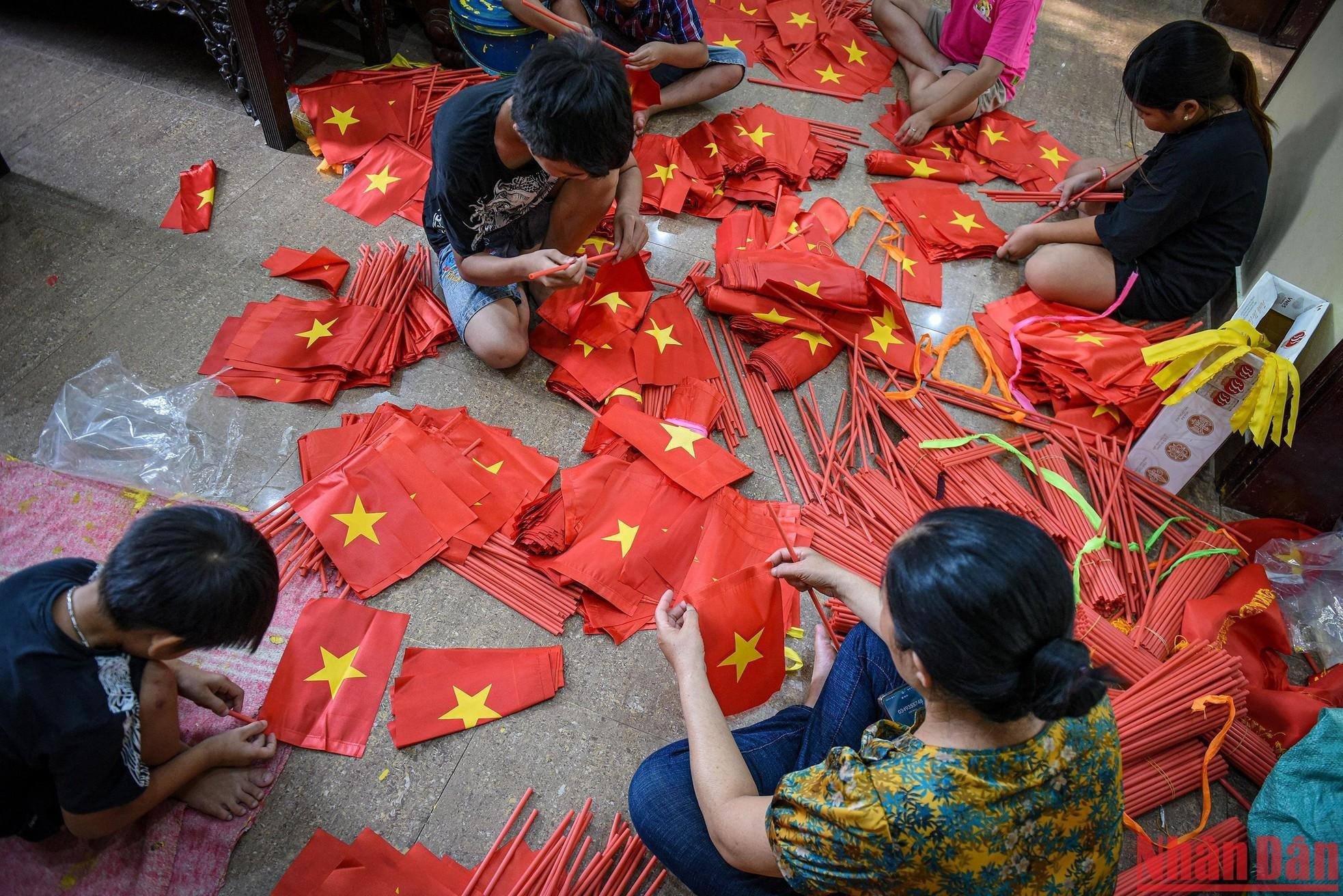 Nhung teaches children in the village to make flags. Nhung teaches children in the village to make flags.