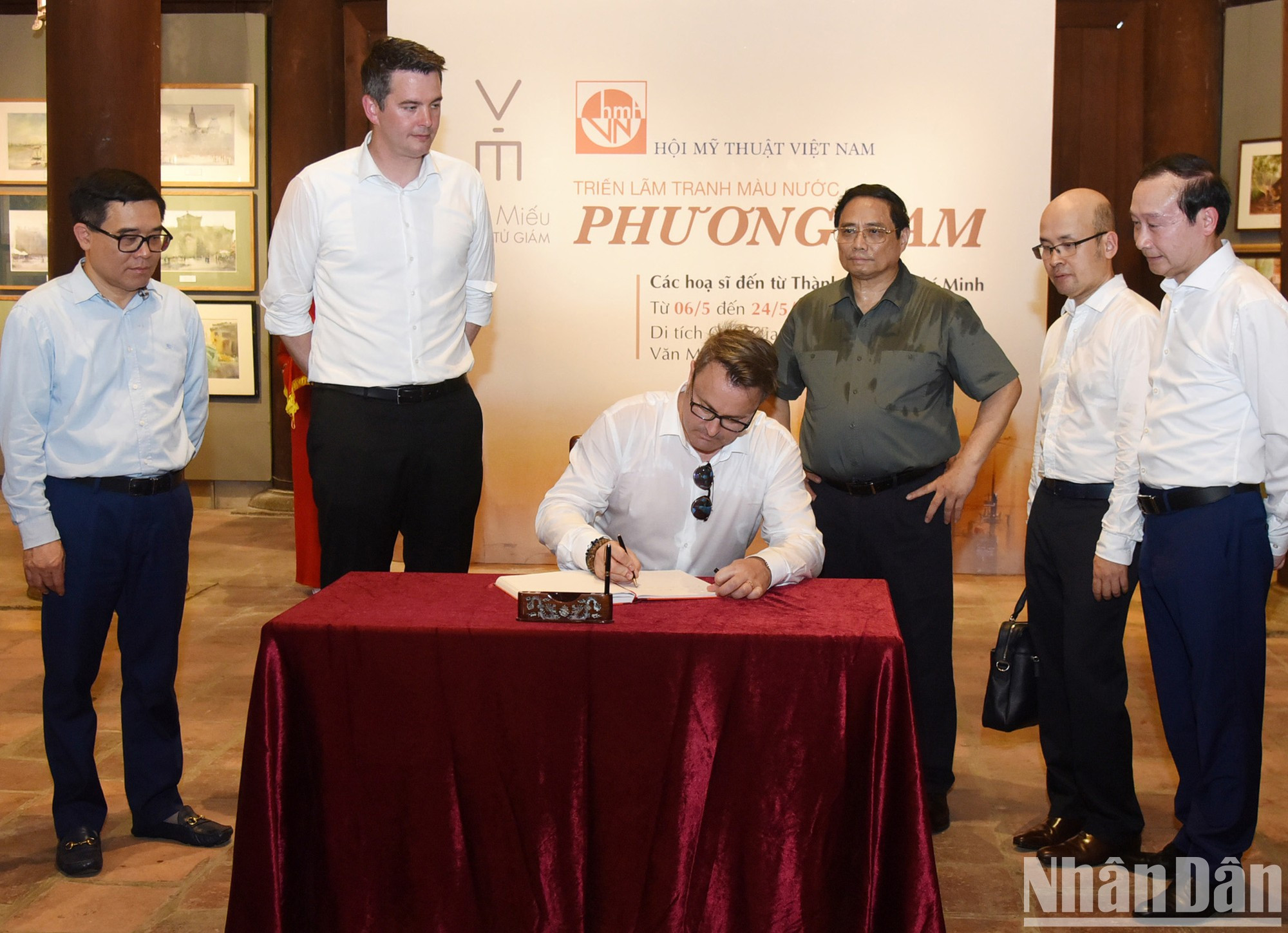 Luxembourg Prime Minister Xavier Bettel writes on the golden book.