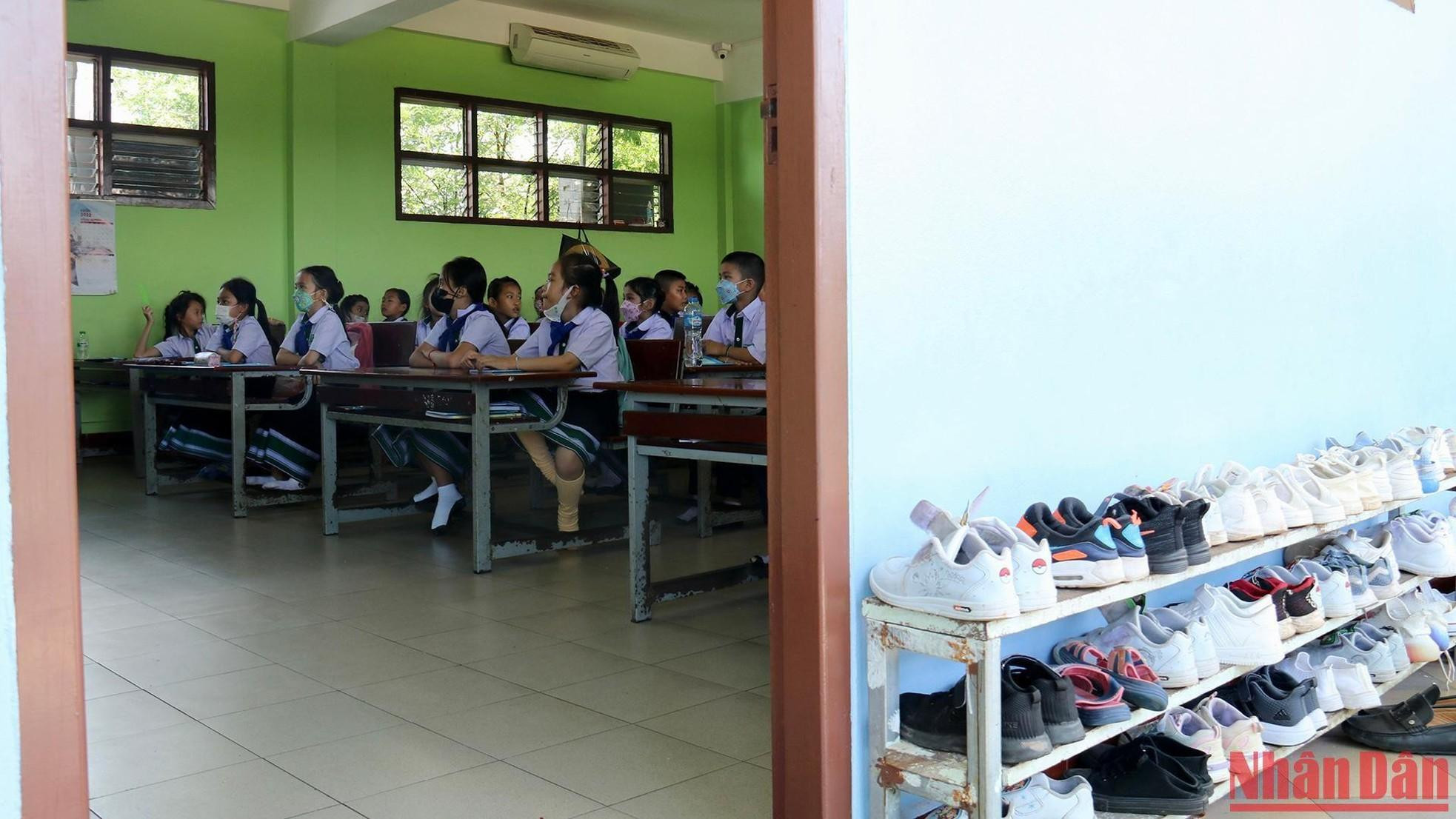 Shoes are neatly arranged outside the classroom door.