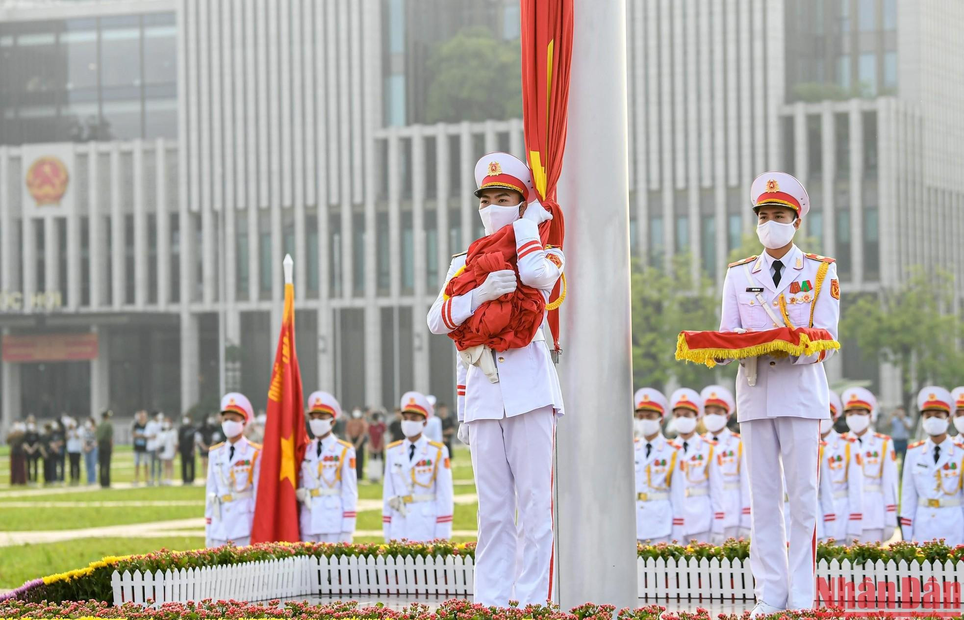 The soldier who holds the red flag waits for the command and the national anthem.