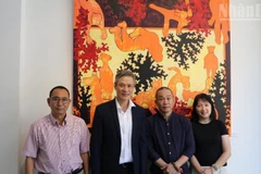 Vietnamese Ambassador to Cambodia Nguyen Minh Vu (in a black suit) attends the exhibition of painter Bui Hoang Duong (in a black shirt). (Photo: HUY VU)