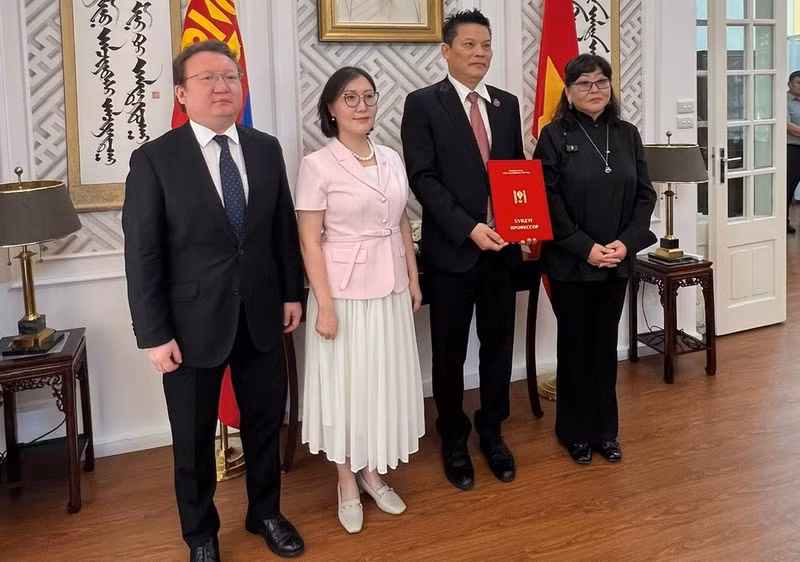 Mongolian Ambassador Ganbaatar Hulan and representatives of the Mongolian State University of Arts and Culture present the title of “Honorary Professor” to director Le Quy Duong. (Photo: MINH GIANG)