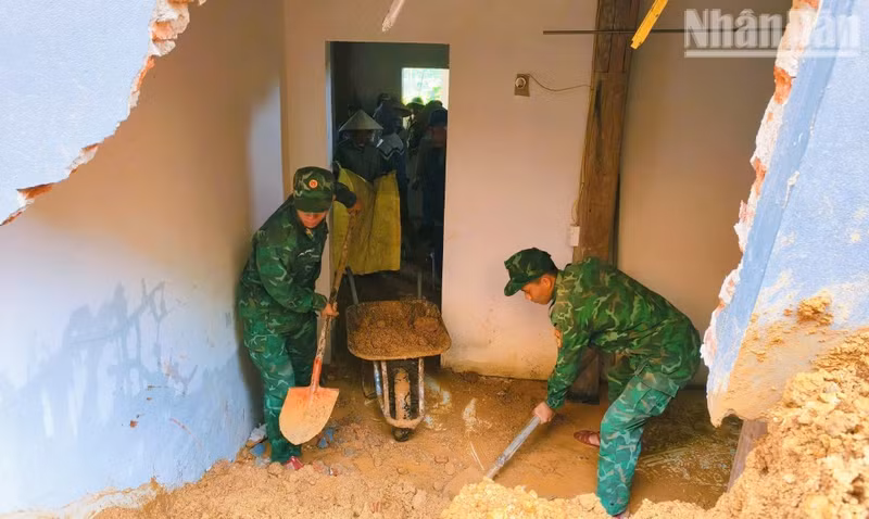 Officers and soldiers of Muong Lan Border Guard Station assist the family of Ha Van May in Na Khi Village, Muong Lan Commune, whose house was affected by landslides caused by storms and rain. (Photo: QUANG HUNG)