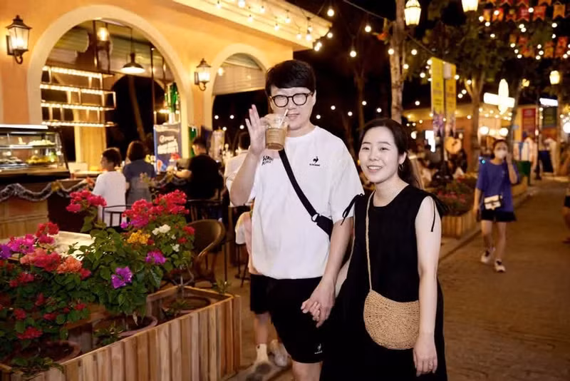 Korean tourists share bright smiles while exploring the diverse international culinary scene at the Vui-Fest Bazaar in Sunset Town. (Photo: Sun Group)