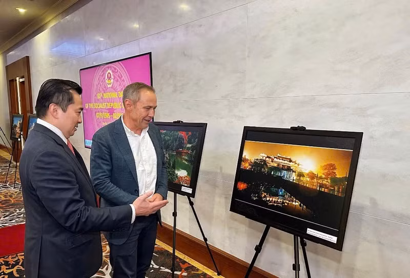 Consul General Pham Hai Anh introduces Western Australian Premier Roger Cook to the beauty of Viet Nam’s land, people and culture through photos displayed at the event. (Photo: The Vietnamese Consulate General in Perth)