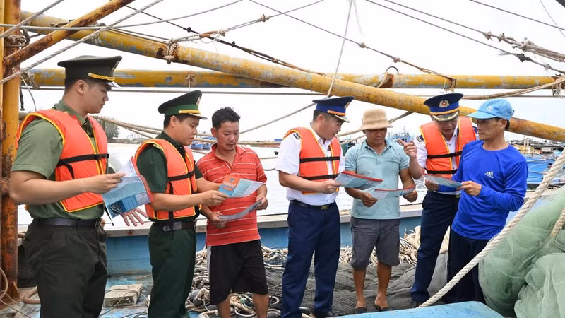 Coast Guard officers and competent forces hand out leaflets to raise fishermen’s awareness of IUU prevention and control. (Photo: Coast Guard)
