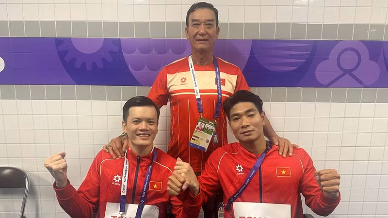 Coach Dang Vien with Le Tien Dat and Do Thanh Hai after their race. (Photo: THU HOAI)