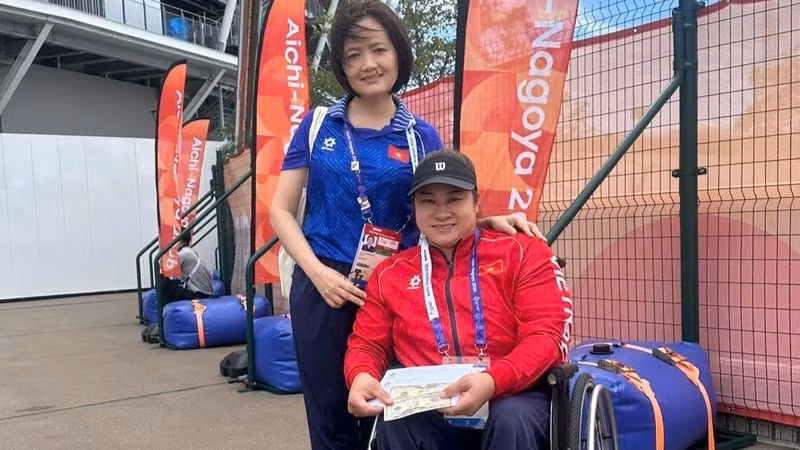 A representative of the Vietnamese para sports delegation presents a bonus to Nguyen Thi Ngoc Thuy after winning bronze in the women’s discus throw F54 at the 5th Asian Para Games in Nagoya, Japan. (Photo: THU HOAI)