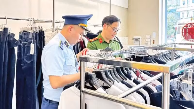 Market surveillance team No. 6 coordinates with Lang Son Provincial Police to inspect and detect many items of clothing and footwear showing signs of counterfeiting famous trademarks at a business store in Dong Kinh Ward. (Photo: LUU QUYEN)