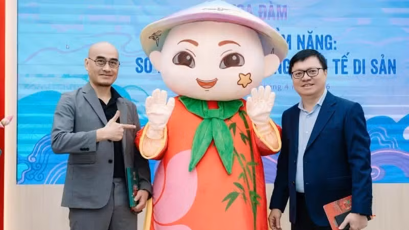 Member of the Party Central Committee, Editor-in-Chief of Nhan Dan Newspaper, Deputy Head of the Party Central Committee's Commission for Communication, Education, and Mass Mobilisation, and President of the Viet Nam Journalists Association Le Quoc Minh, and Dao Trong Huy, Chairman of AnnGroup, pose for a photo with the demo version of the Anh Tre mascot.