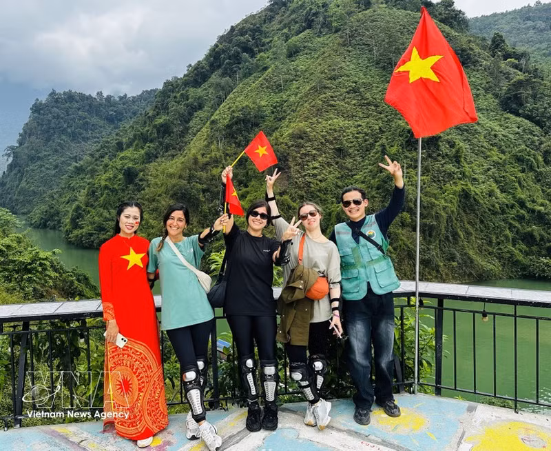 Foreign tourists in a photo with local residents. (Photo: VNA)
