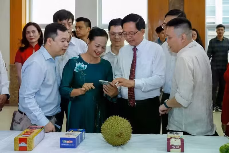 Deputy Prime Minister Ho Quoc Dung and other participants experience Viet Nam's agricultural product traceability system on a durian. (Photo: danviet.vn) 