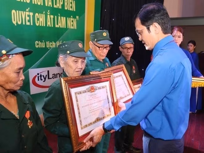 Bui Quang Huy, alternate member of the Party Central Committee, Vice President of the Viet Nam Fatherland Front Central Committee and First Secretary of the Ho Chi Minh Communist Youth Union Central Committee, presents the "Glorious Youth Volunteer" medal to former youth volunteers at the ceremony. (Photo: VNA)