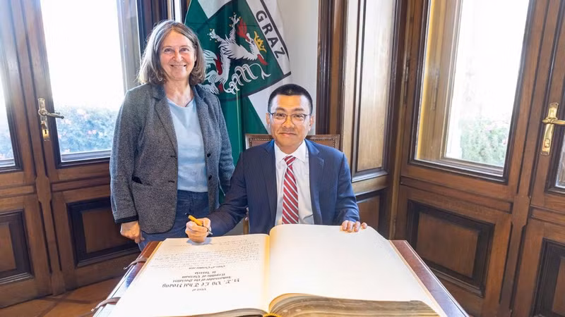Elke Kahr, leader of the Communist Party and Mayor of Graz, and Ambassador Vu Le Thai Hoang sign the golden book of Graz City. (Photo: TL)
