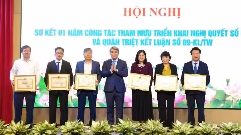 Minister of Justice Nguyen Hai Ninh presents Certificates of Merit from the Prime Minister to collectives and individuals for outstanding achievements in advising on, and organising the implementation of, Resolution No. 66-NQ/TW. (Archive photo)