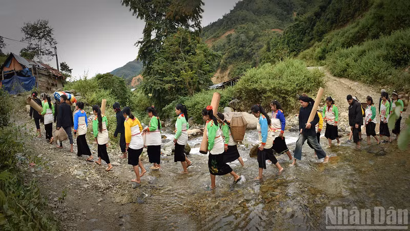 The wedding procession crosses the stream. (Photo: Vu Linh)