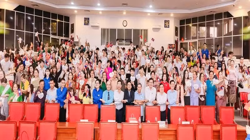 The sponsoring families, Lao and Cambodian students, and organisers pose for a commemorative photo.