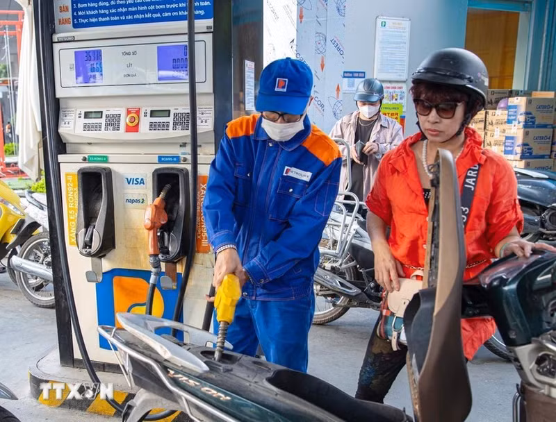 A motorcyclist has her vehicle refilled at a petrol station of Petrolimex. (Photo: VNA)