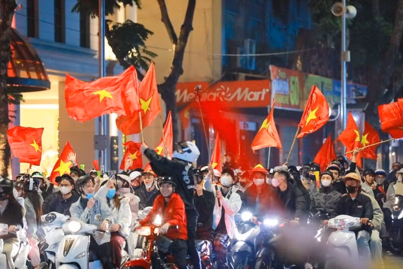 Residents in Ha Noi celebrate the Vietnamese U22 team's win at the 33rd SEA Games on December 18 evening. (Photo: VNA)