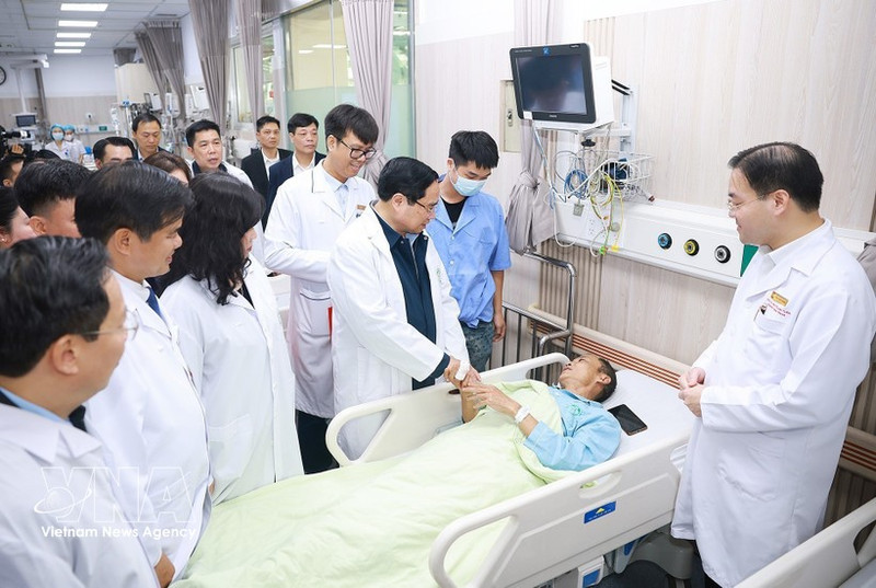 Prime Minister Pham Minh Chinh visits and extends Lunar New Year greetings to a patient undergoing treatment at Bach Mai Hospital. (Photo: VNA)