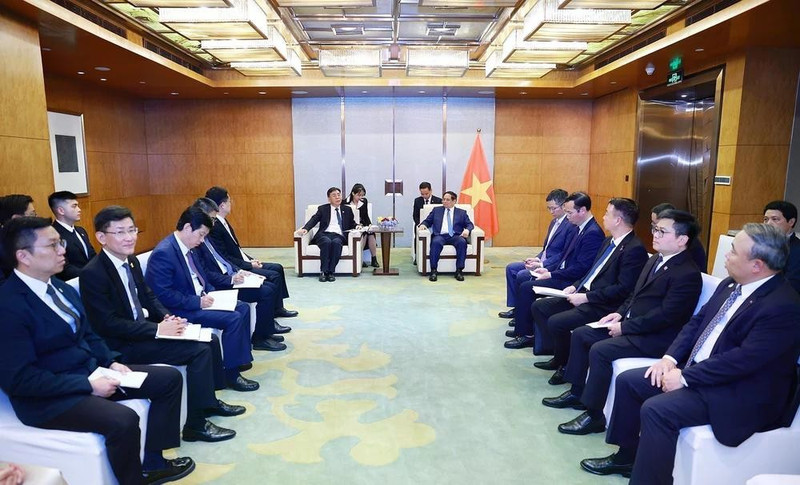 Prime Minister Pham Minh Chinh (right) works with Vice Chairman of COMAC Shen Bo. (Photo: VNA)