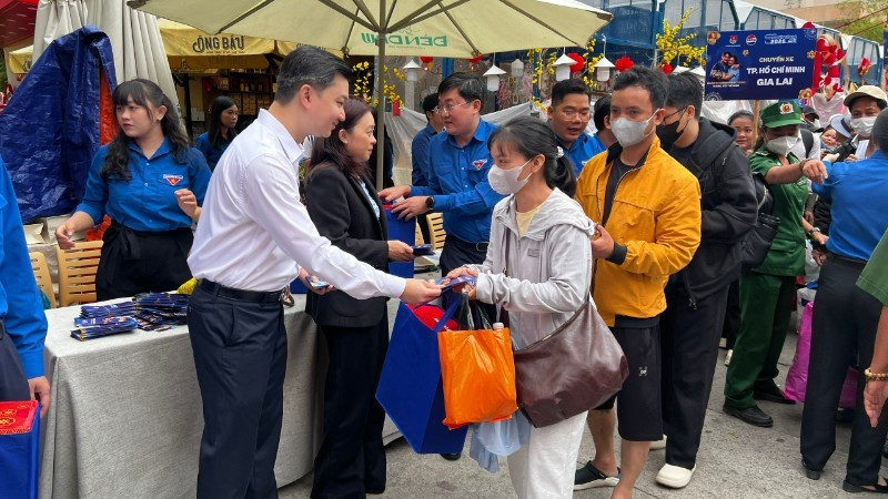 Representatives of the Organising Committee present gifts and lucky money to people before their departure home for Tet (Lunar New Year).