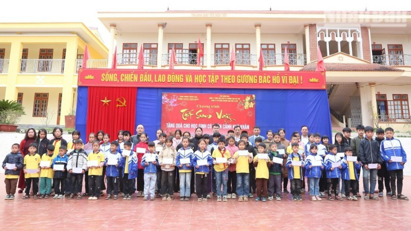 Representatives from various organisations present Tet gifts to 62 disadvantaged students at Chieng Ngan A Primary and Secondary School. (PHOTO: PHAN THAO)