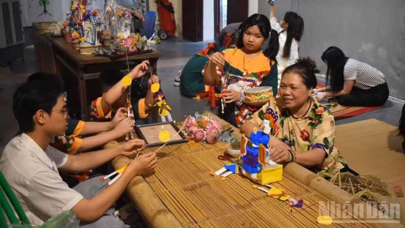 Artisan Nguyen Thi Tuyen introduces “paper doctor” toys to young people.