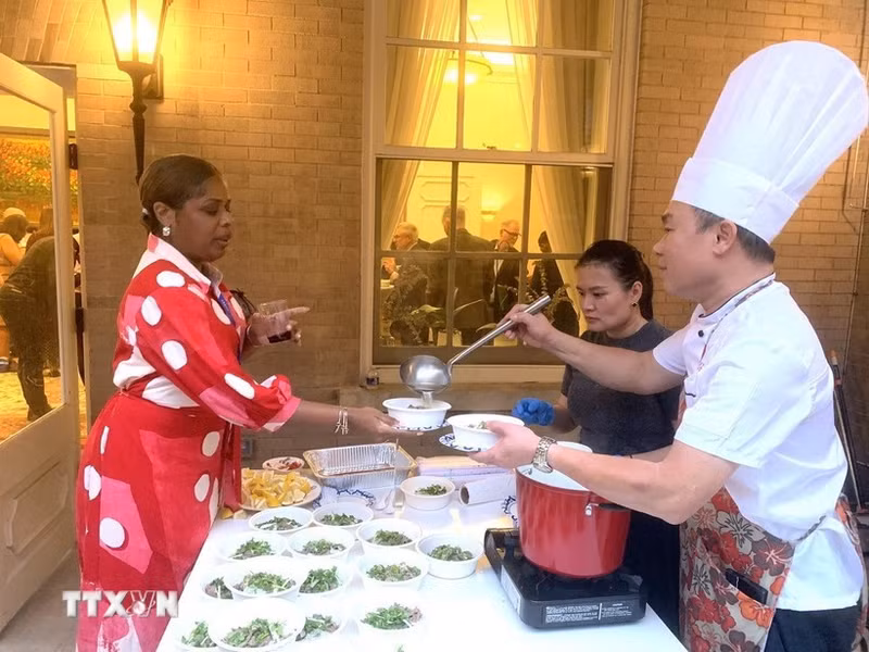 People enjoy beef "pho" - a traditional dish seasoned with typical Vietnamese spices at the event. (Photo: VNA)