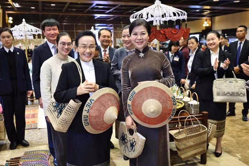 Ngo Phuong Ly (R), spouse of the Vietnamese Party General Secretary, and visiting Naly Sisoulith, spouse of the Lao Party General Secretary and President, take part in an exchange with outstanding artisans from several traditional craft villages of Ninh Binh province on January 27. (Photo: VNA)
