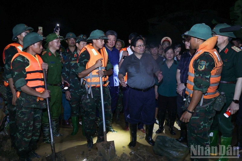 Prime Minister Pham Minh Chinh visits the forces working to reinforce the Cau River embankment, emphasising the need to ensure the dike’s safety. (Photo: NDO)