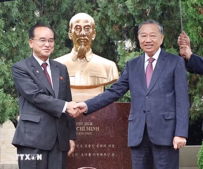 General Secretary of the Communist Party of Viet Nam Central Committee To Lam (R) and Cho Yong Won, member of the Presidium of the Political Bureau, Secretary of the Central Committee, and head of the Organisation and Guidance Department of the WPK, shake hands in front of the statue. (Photo: VNA)