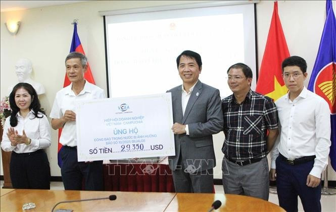 A representative of the Viet Nam–Cambodia Business Association (VCBA) presents its donated fund to the leaders of the Vietnamese Ambassador to Cambodia Nguyen Minh Vu (2nd from left). (Photo: VNA)