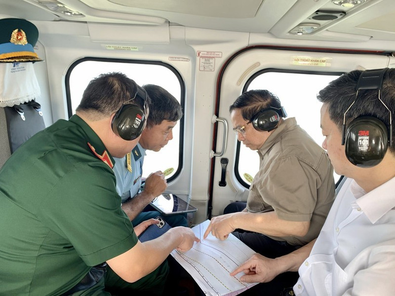 Prime Minister Pham Minh Chinh (second from right) conducts an aerial inspection of the Ca Mau–Dat Mui expressway, the road leading to Hon Khoai, and the dual-use Hon Khoai port from a helicopter. (Photo: VNA) 