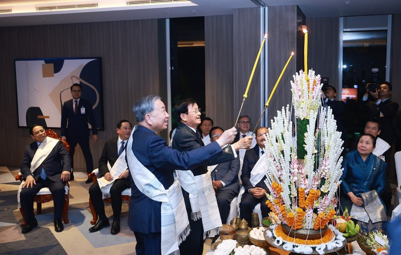 Party General Secretary To Lam (right) and Lao Party General Secretary and President Thongloun Sisoulith take part in Laos’ traditional wrist-tying ceremony on February 5. (Photo: VNA)