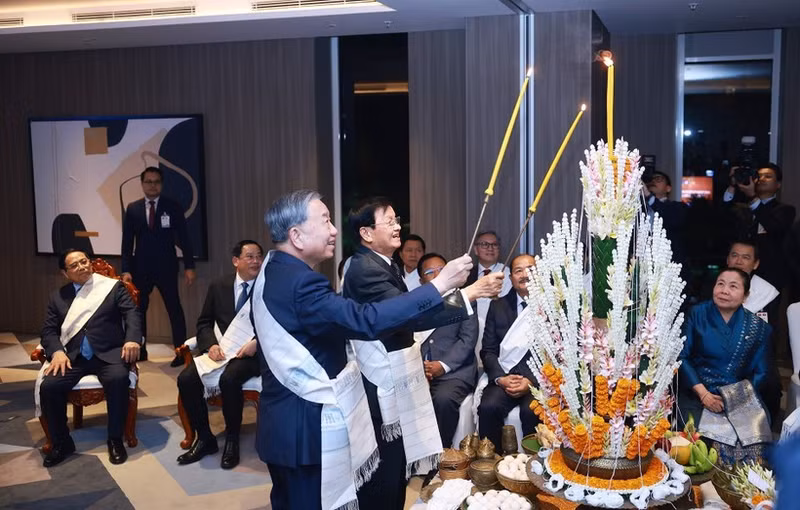 Party General Secretary To Lam (right) and Lao Party General Secretary and President Thongloun Sisoulith take part in Laos’ traditional wrist-tying ceremony on February 5. (Photo: VNA)