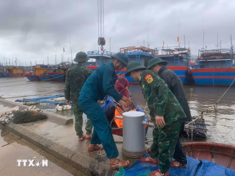 Border guard officers at Ky Ha Port Border Gate are assisting residents in securing their boats. (Photo: VNA)