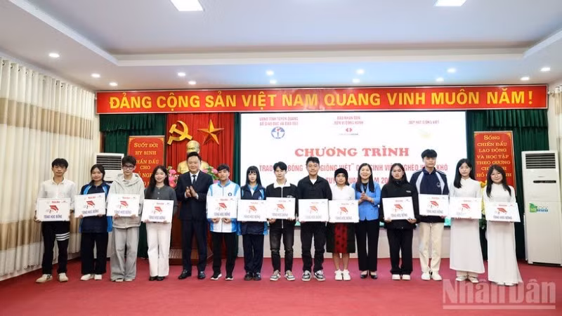 Phan Van Hung, Deputy Editor-in-Chief of Nhan Dan Newspaper, and Le Thi Thanh Tra, Vice Chairwoman of the Tuyen Quang Provincial People’s Council, presented scholarships to disadvantaged students.