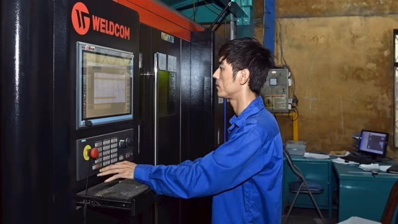 Operating a mechanical manufacturing line at Tomerco An Khang Company, Ngoc Liep Industrial Cluster (Hanoi). (Photo: TUE NGHI)