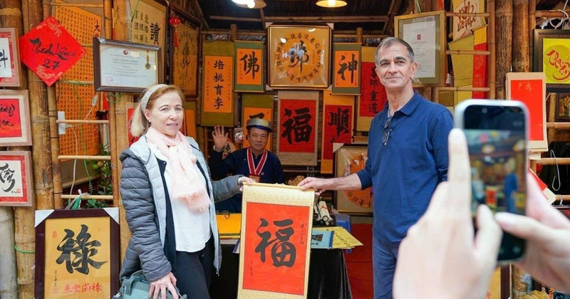 International visitors experience the traditional new year calligraphy activity (Photo: VNA)