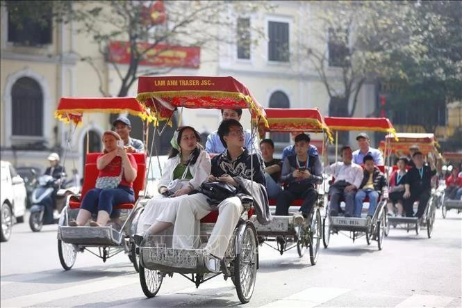 Tourists experience a cyclo ride around Hoan Kiem Lake (Photo: VNA)