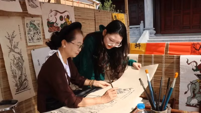 Visitors learn about the process of making Dong Ho folk paintings. (Photo: VNA)