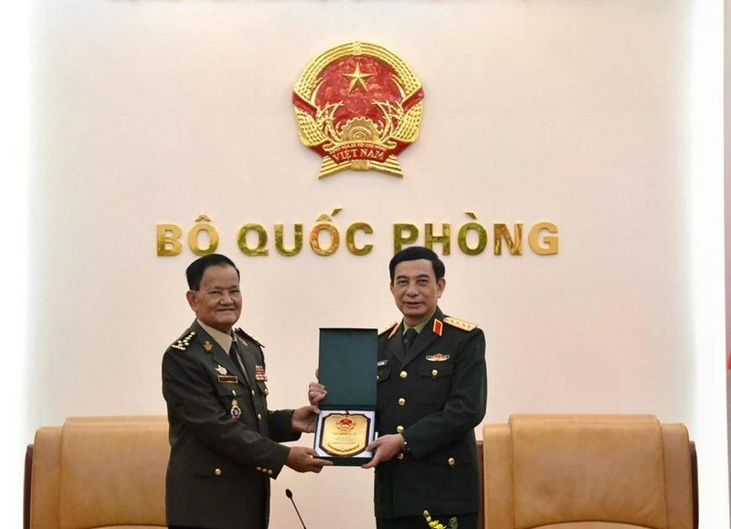Minister of National Defence Gen. Phan Van Giang (R) hands over a gift to Secretary of State at the Cambodian Ministry of National Defence Gen. Prum Din at their meeting in Ha Noi on March 9 (Photo: qdnd.vn)