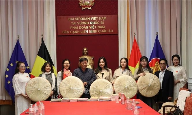 Do Phuoc Trung, Deputy Director of the Ho Chi Minh City Department of Culture and Sports, presents non quai thao to the Vietnamese Ao Dai Heritage Club in the Kingdom of Belgium.