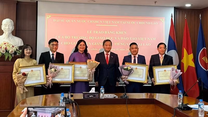 Ambassador Nguyen Minh Tam presents Certificates of Merit to five Vietnamese-language teachers in Laos. (Photo: DUY TOAN)
