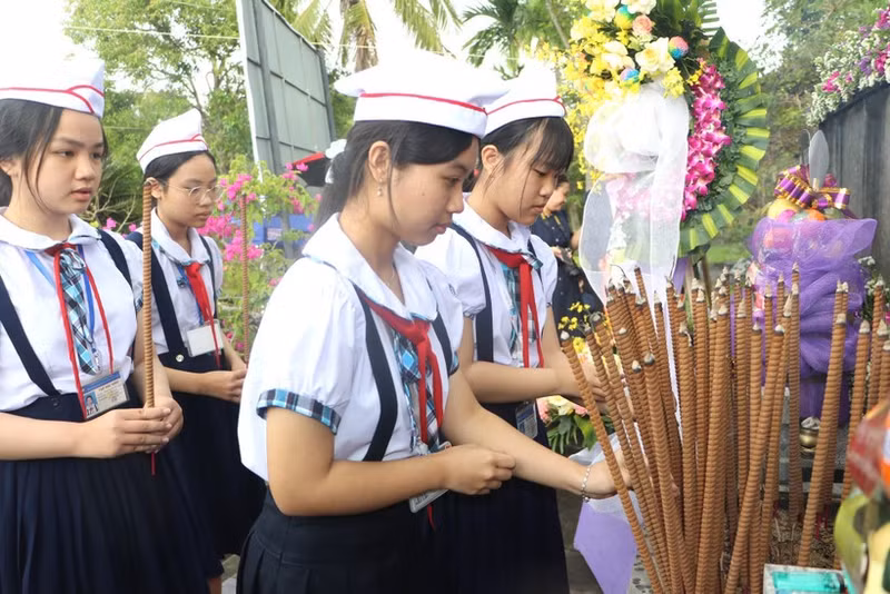 Students offer incense in memory of the 504 innocent civilians killed in the Son My Massacre 58 years ago. (Photo: VNA)