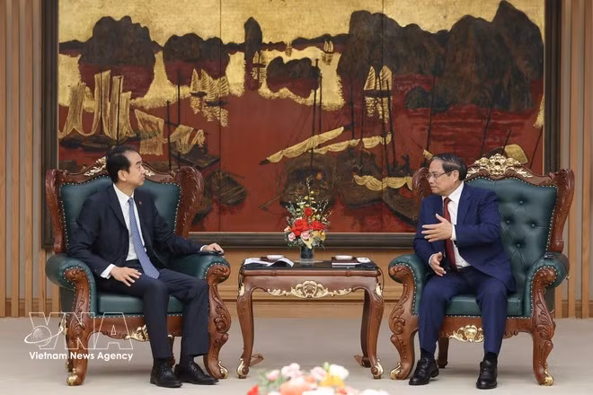 Prime Minister Pham Minh Chinh (R) hosts a reception for Chinese Ambassador to Viet Nam He Wei at the Government Headquarters in Hanoi on April 5. (Photo: VNA)