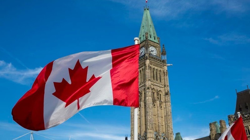 The Canadian flag flies over Parliament Hill in Ottawa. (Photo: Government of Canada)